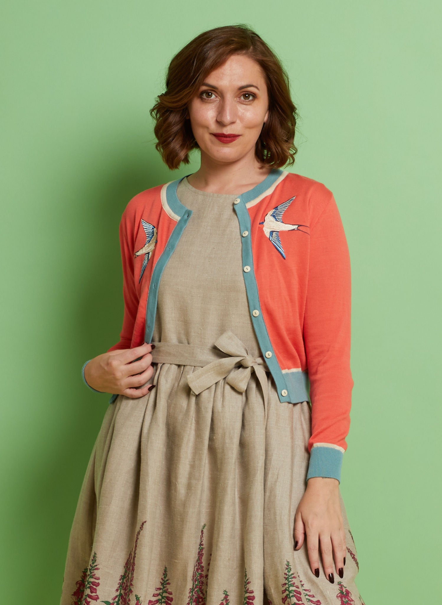 Palava Women's cardigan in coral pink with blue trims and embroidered swallows
