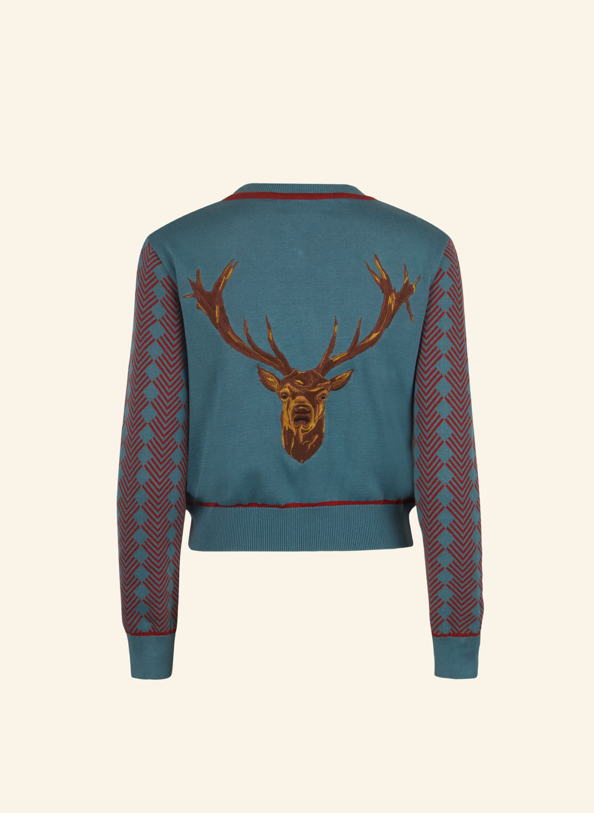 A teal blue cropped knit sweater shown from the back, featuring a large embroidered brown stag head with antlers across the center and red patterned knit sleeves.