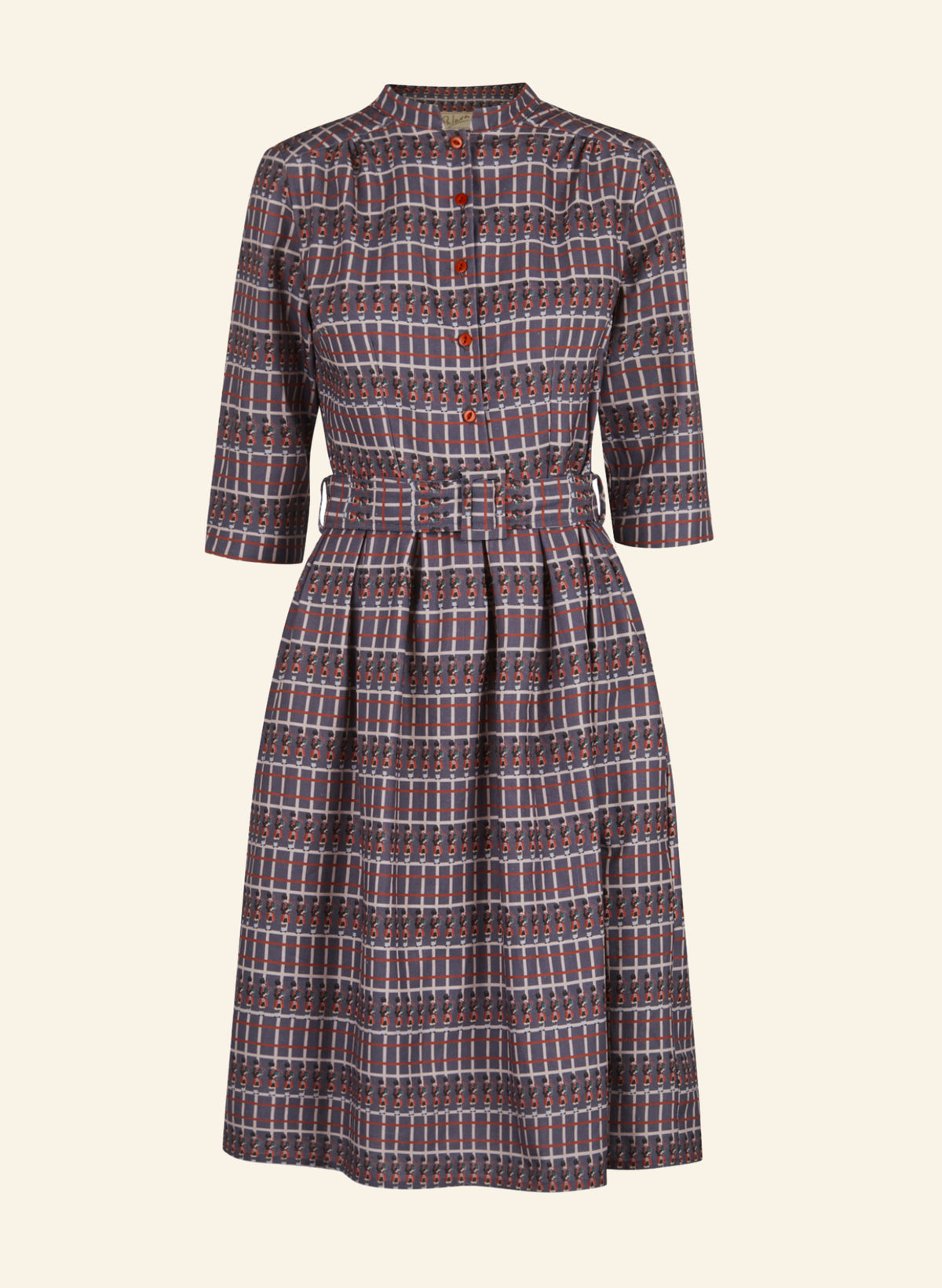 A vintage-style A-line dress with a red, blue, and white plaid pattern, featuring a button-up front, three-quarter sleeves, and a matching fabric tie belt at the waist, shown against a solid cream background.