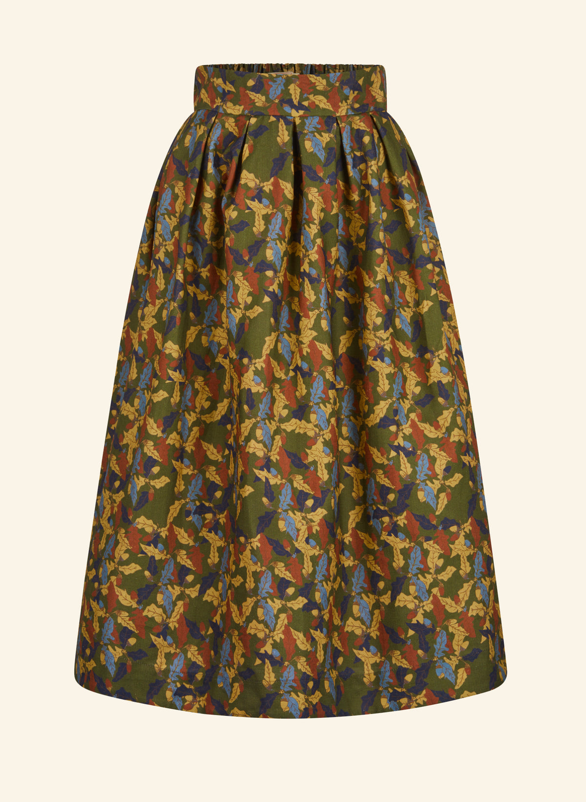 A high-waisted, pleated A-line skirt featuring an intricate multicolor jacquard pattern with olive green, mustard yellow, rust red, and blue tones, shown against a solid cream background.
