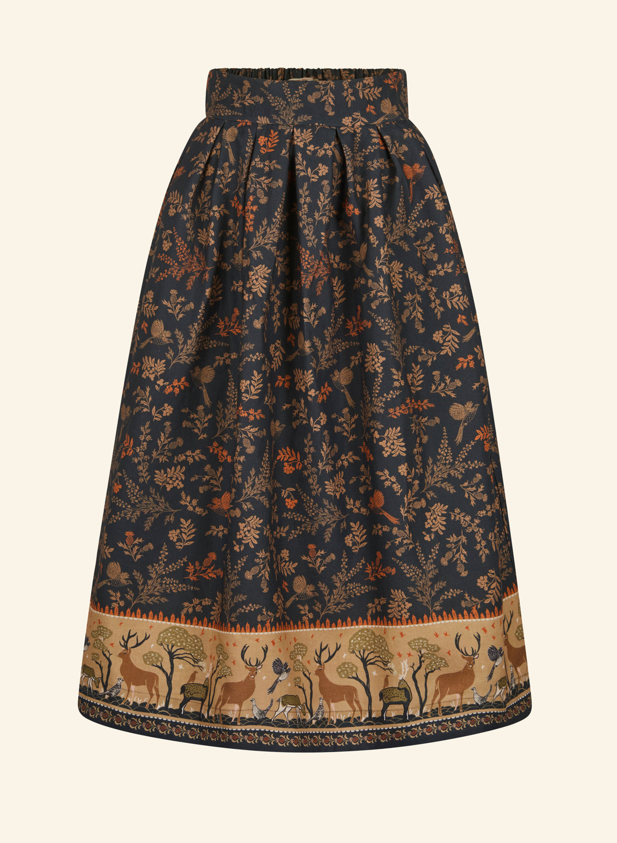 A high-waisted A-line skirt in dark navy blue with an all-over brown and rust floral print, featuring a decorative border of deer and trees at the hem, shown against a light cream background.
