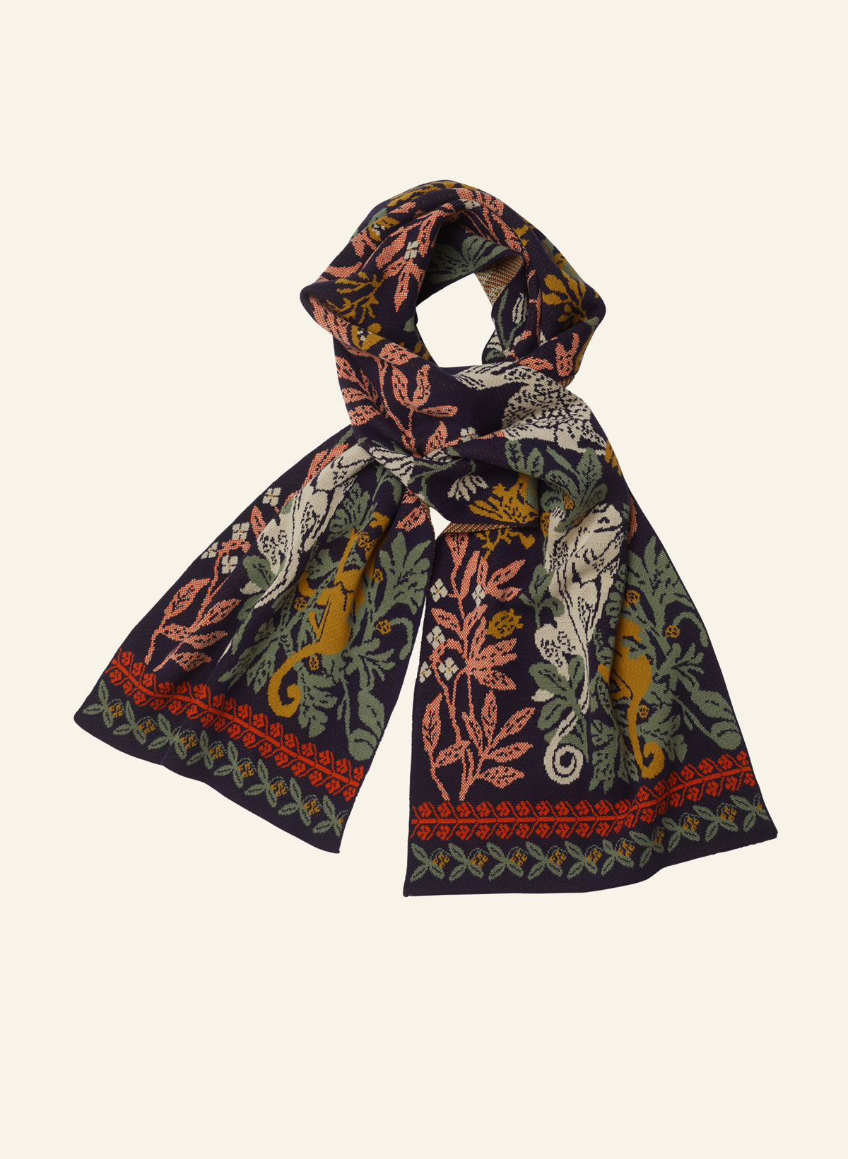 A lightweight rectangular scarf with an intricate botanical and animal print, featuring leopards, birds, and foliage in muted tones of green, mustard yellow, terracotta, and cream on a dark navy base, shown against a solid off-white background.