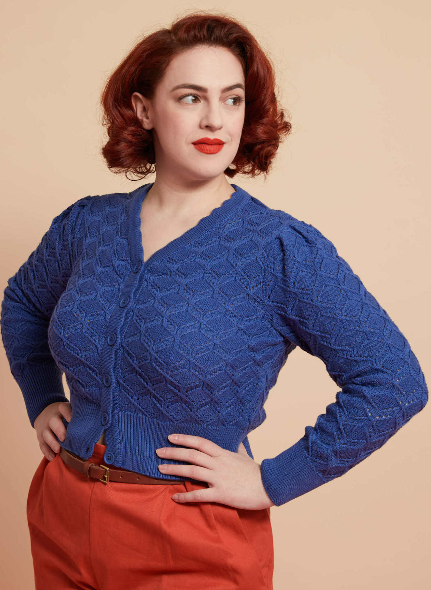 Woman wearing blue 1940s style cardigan with long sleeves and v neck