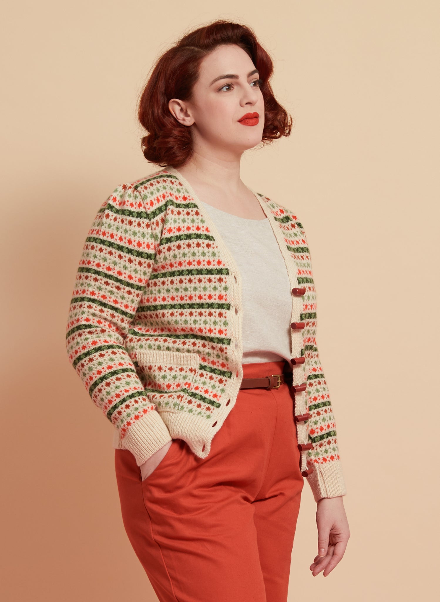 green and red striped vintage-style geometric knit cardigan made in the UK from 100% british wool, with slightly puffed sleeves and wooden buttons