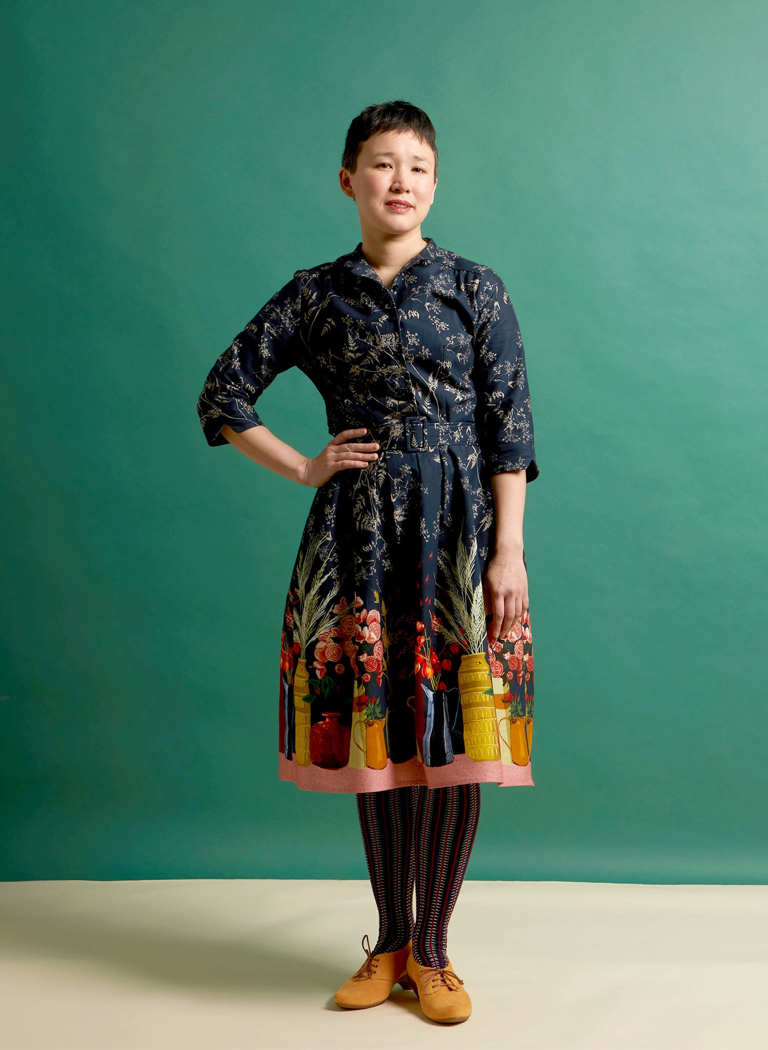 organic cotton navy knee-length belted shirt dress with 3/4 length sleeves, pockets, and a floral print