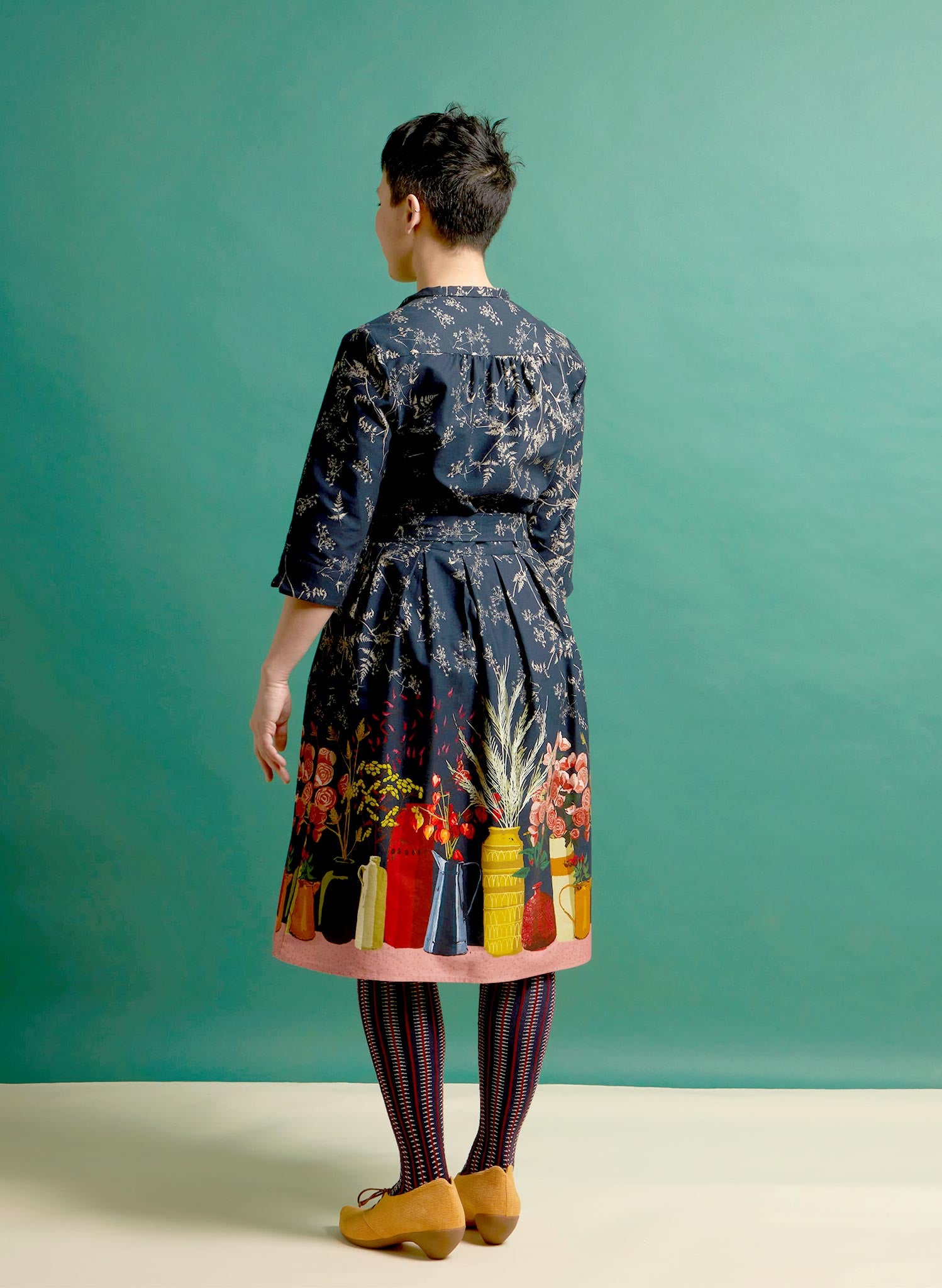 organic cotton navy knee-length belted shirt dress with 3/4 length sleeves, pockets, and a floral print