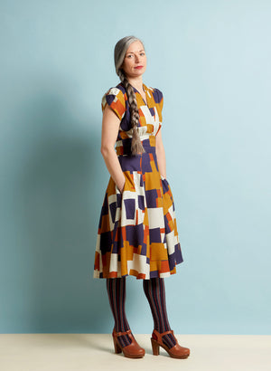 Multi coloured short sleeve dress with full knee length skirt in blue, mustard yellow, orange and white geometric print